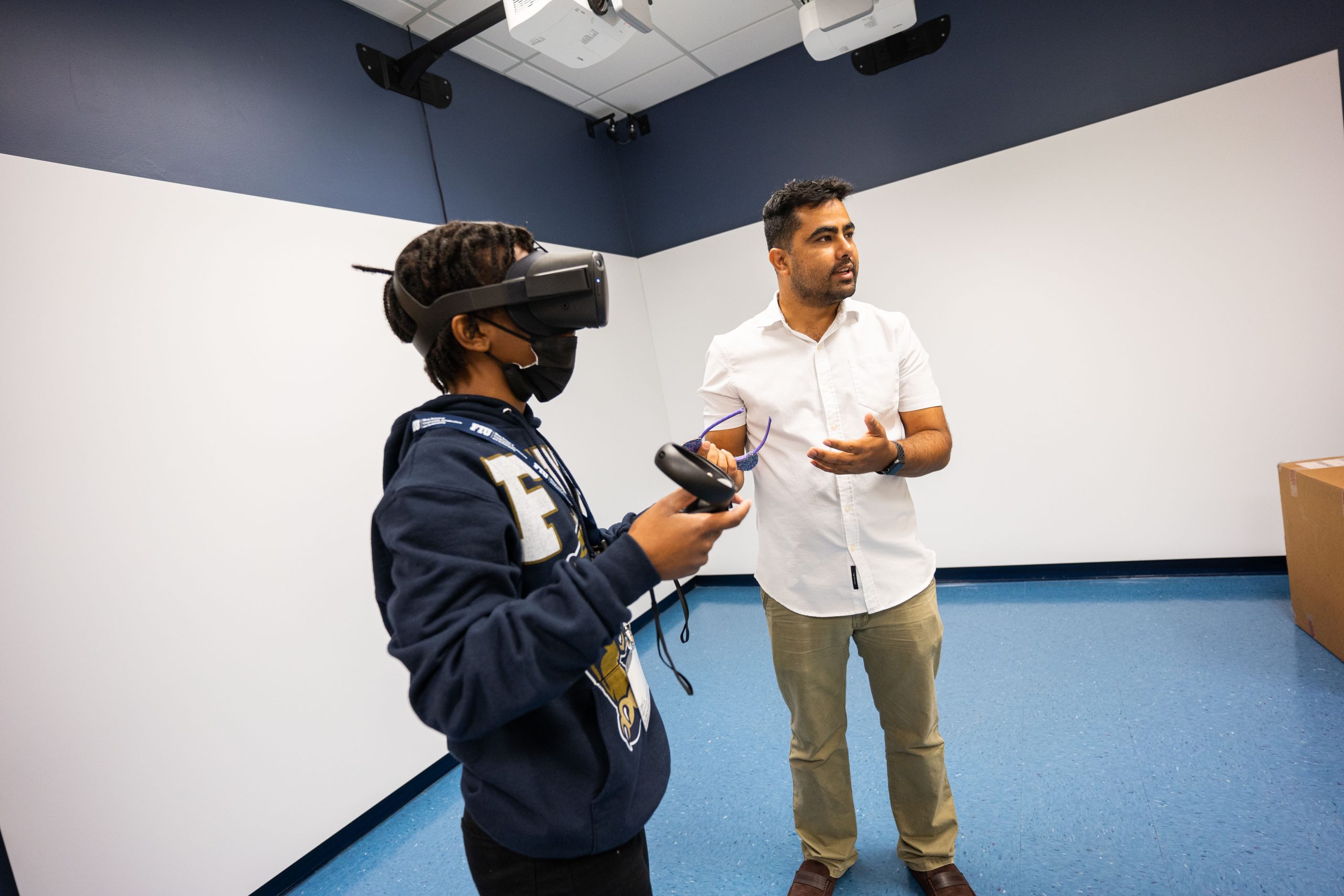 2 individuals manipulating VR Headset